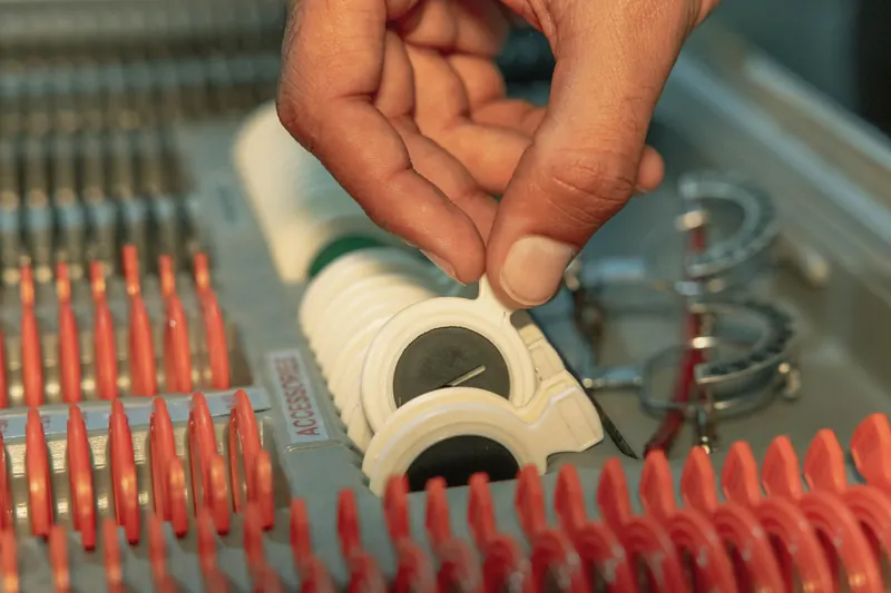 Optometrist choosing lens from optical kit highlighting precision in inspection