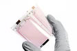 Gloved hand holding a flexible display sheet showcasing cutting-edge coating technology