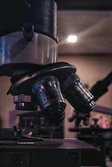 Detailed view of microscope lenses in a dimly lit laboratory setting